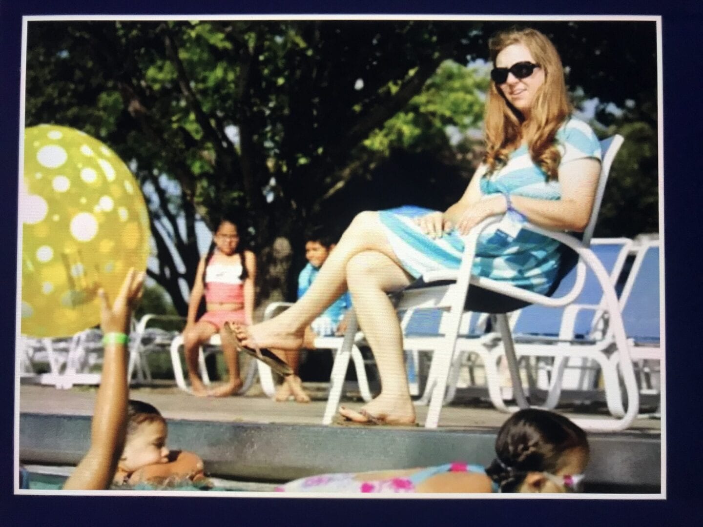 A woman sitting on a chair next to some kids