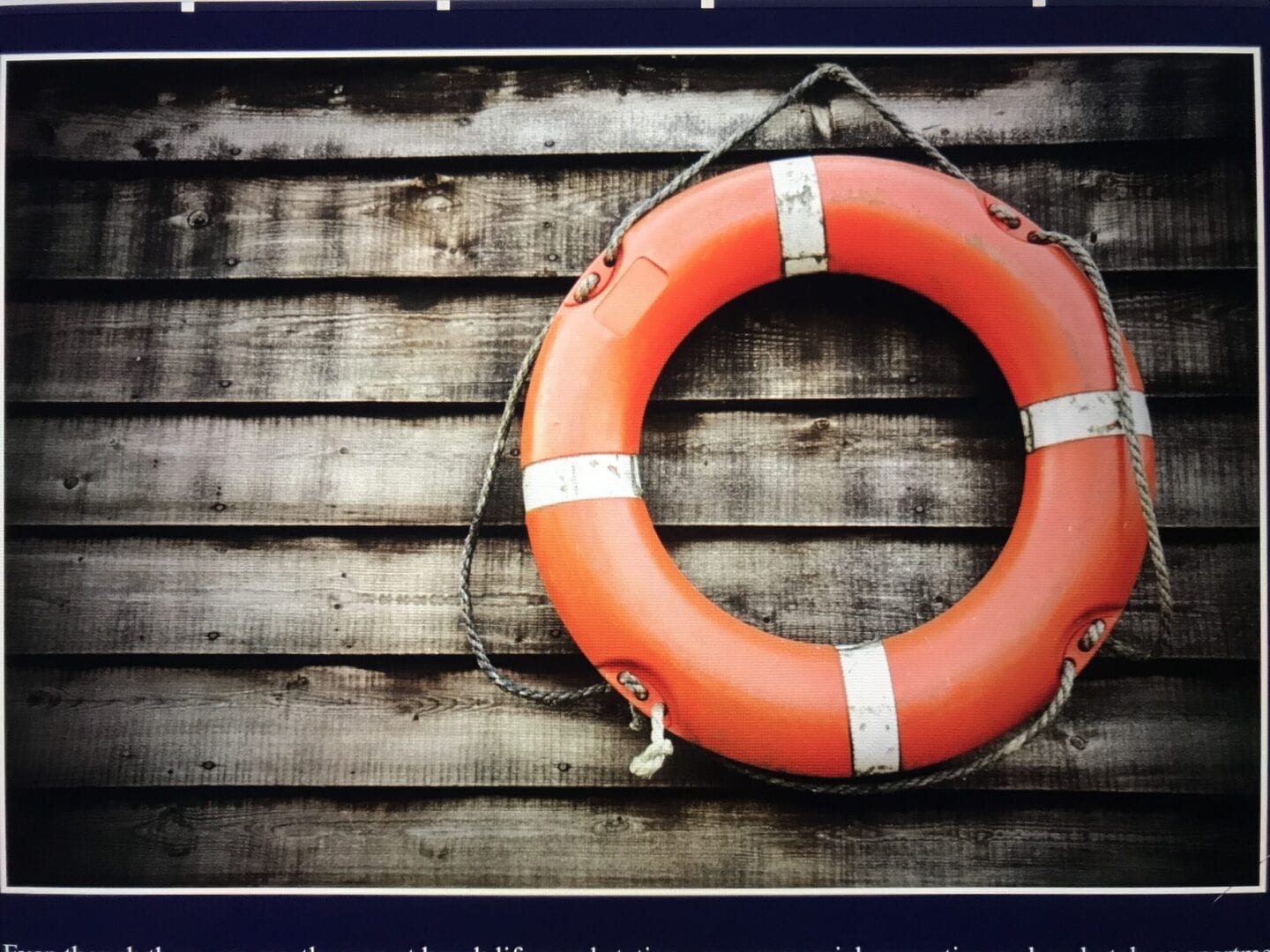 A life preserver hanging on the side of a building.