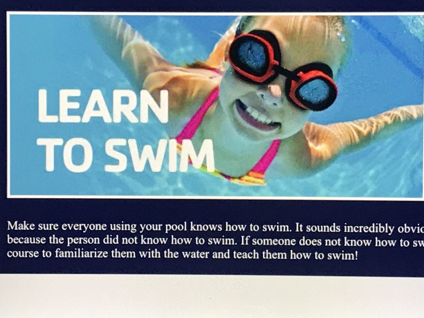 A girl swimming in the water with goggles on.