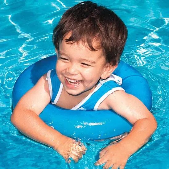 A little boy in the water with an inflatable ring.