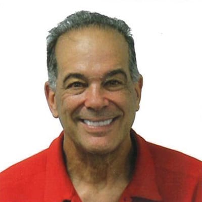 A man in red shirt smiling for the camera.