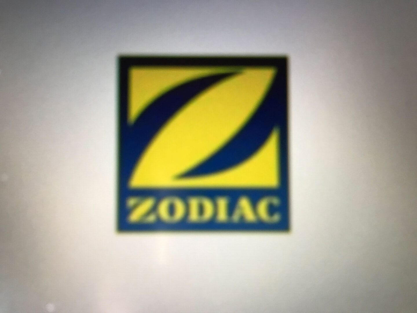 A yellow and blue zodiac logo on a white wall.