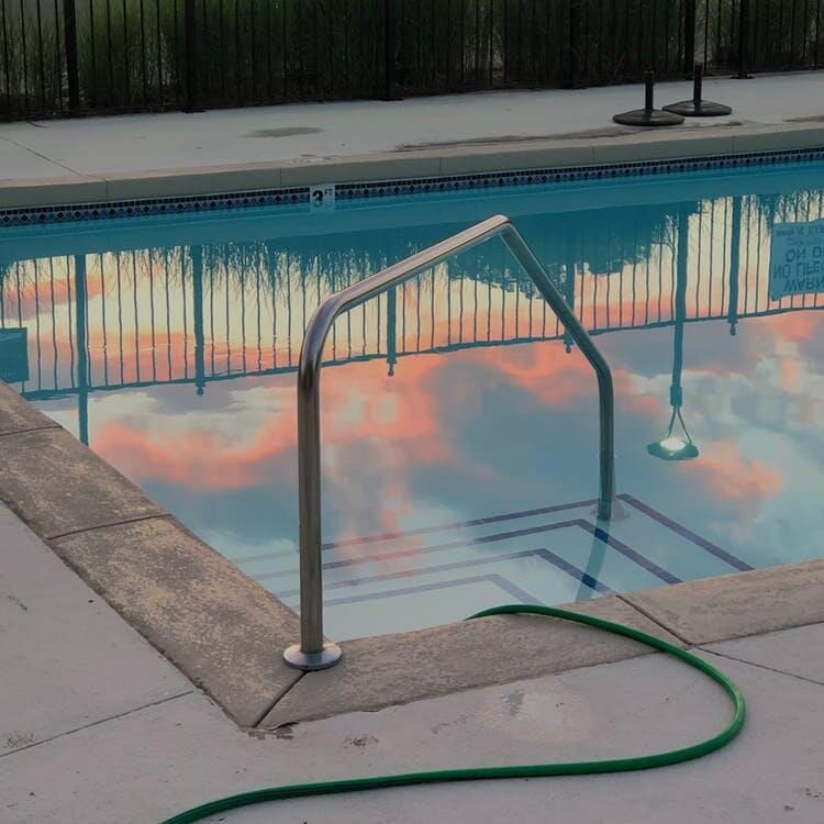 A pool with a green hose next to it