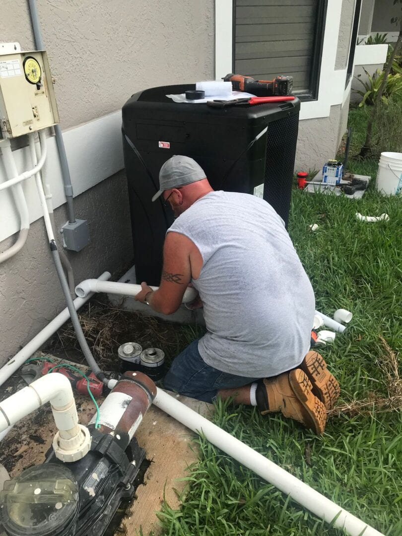 A man working on an outside unit