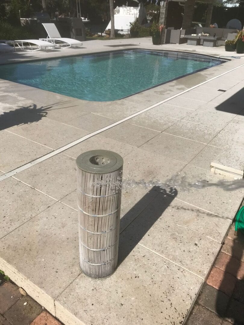 A pool with a concrete pole and a swimming pool.