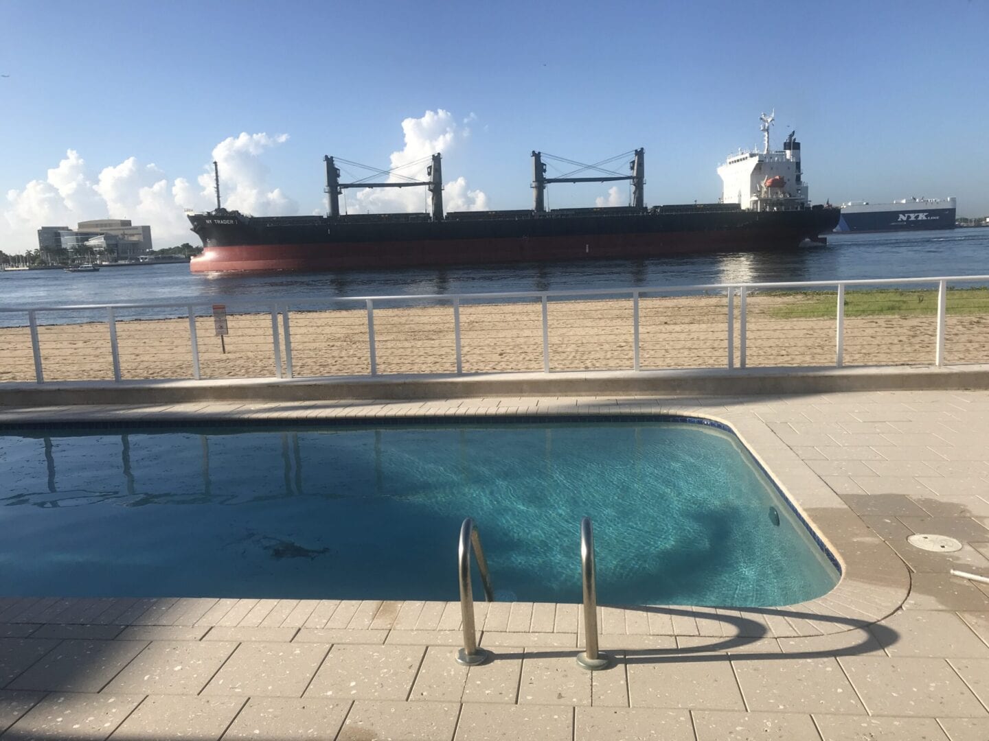 Rounded rectangle pool near the ocean and a big ship nearby (different angle)
