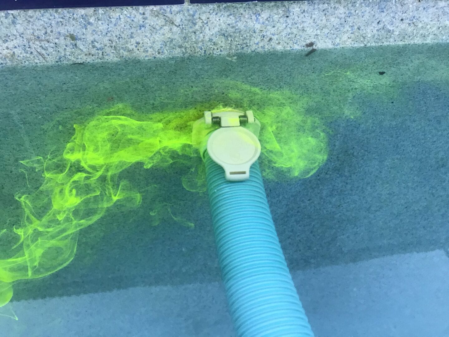 Yellow liquid swirling around a pipe in the pool
