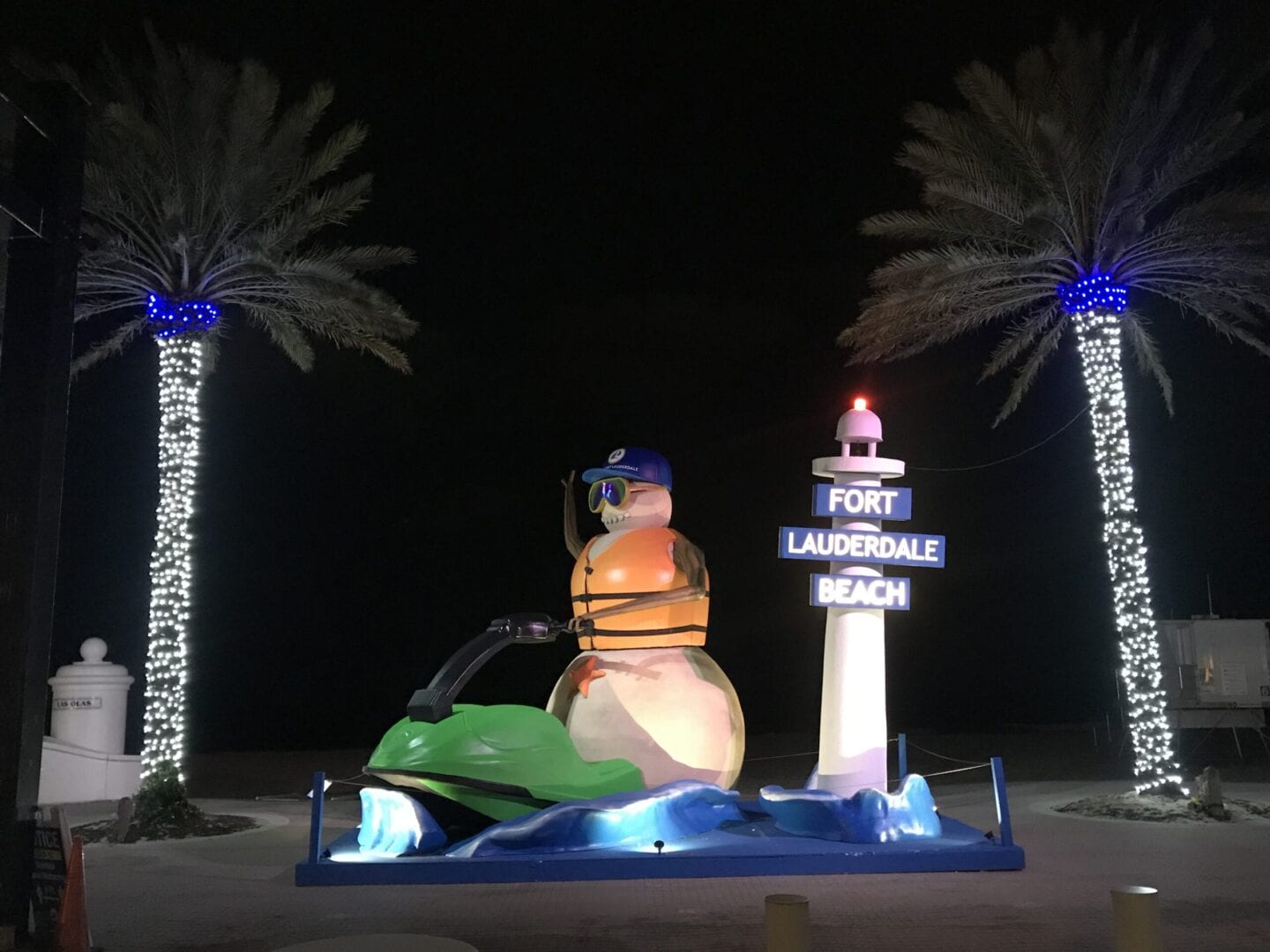 Snowman on a jetski and a lighthouse with a sign “Fort Lauderdale Beach”