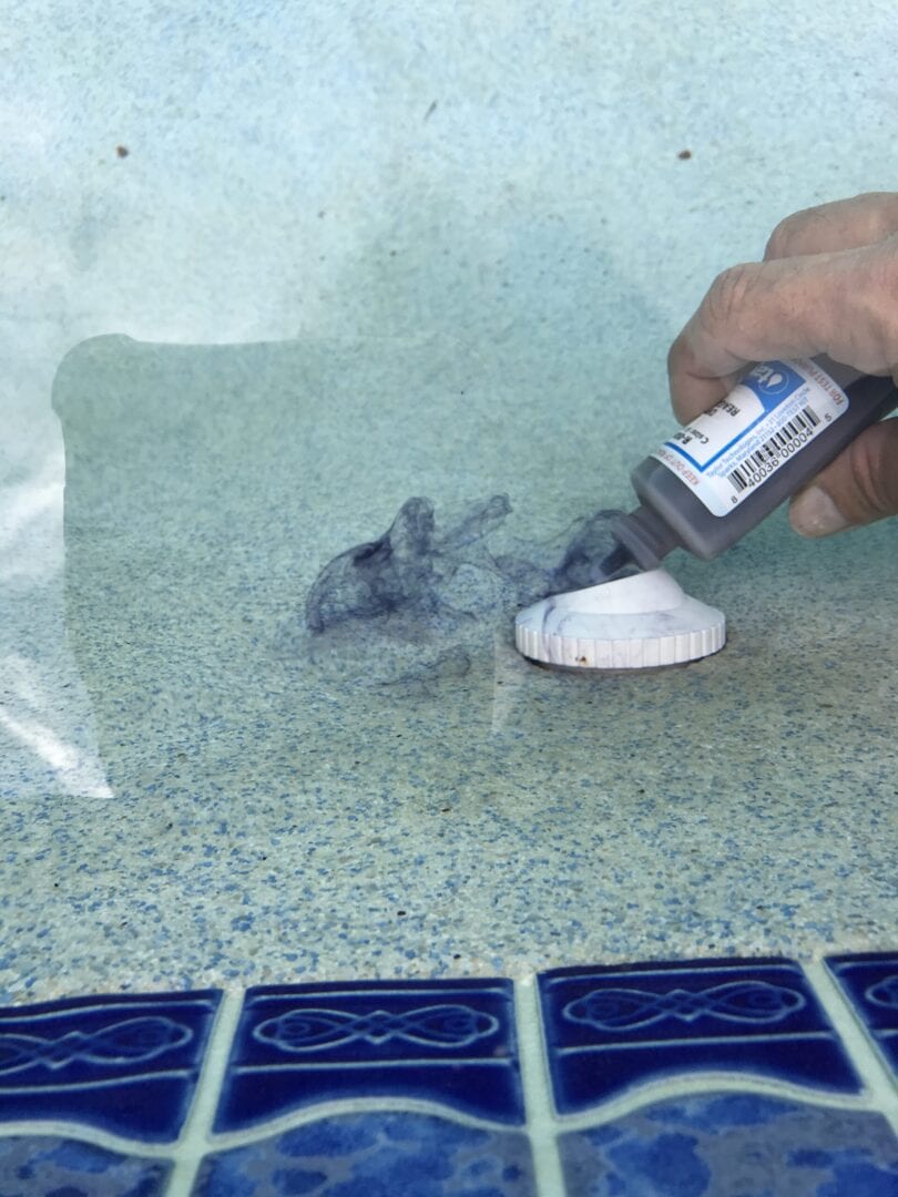 Pouring chlorine PH test solution in a swimming pool