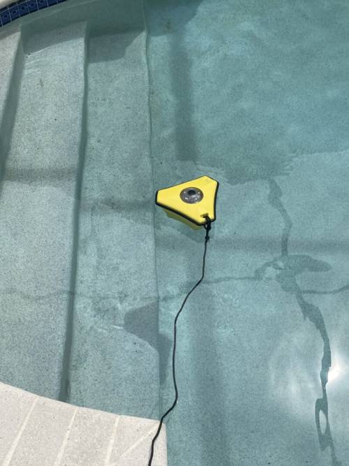 A yellow triangle in the middle of a pool.